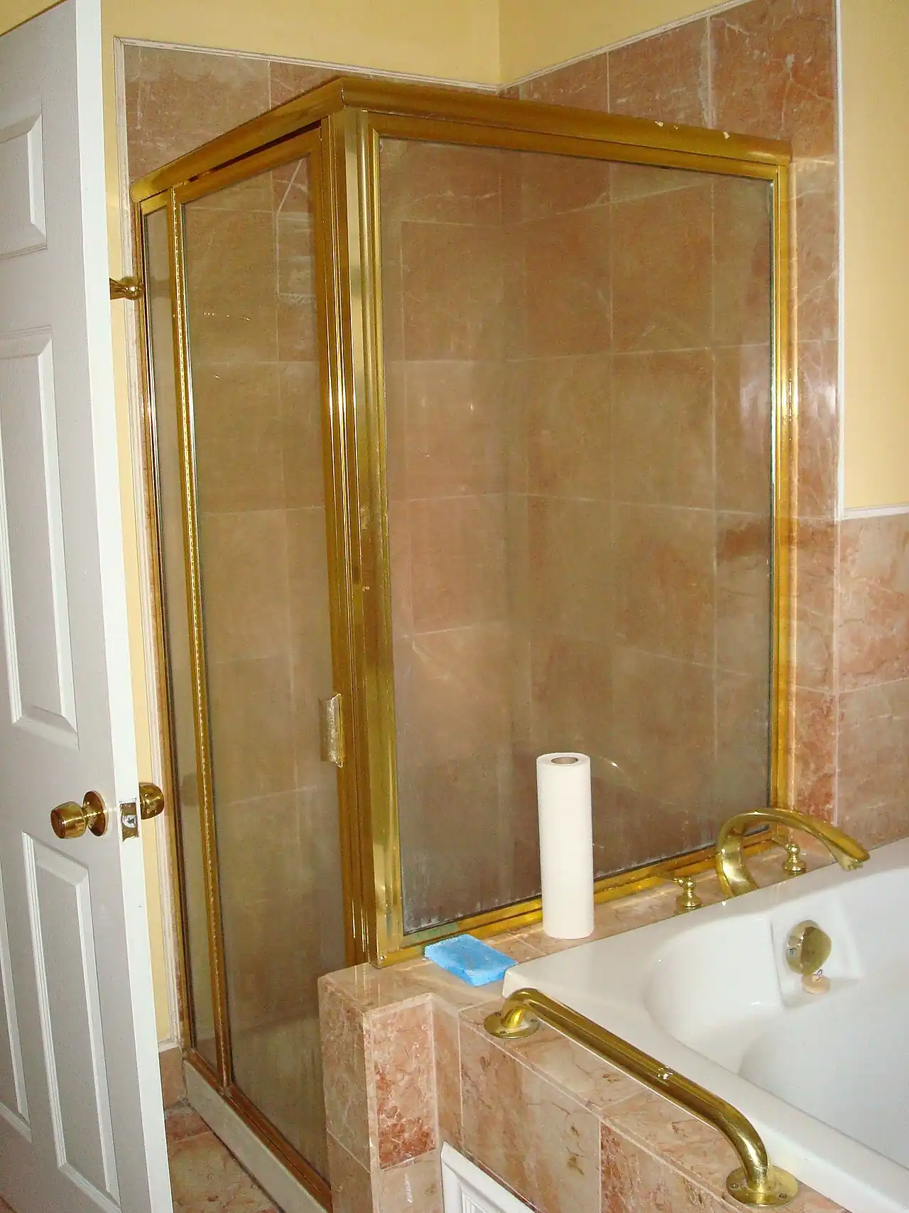 Dated bathroom with an old shower enclosure and worn fittings before renovation